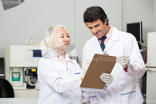 Image of Scientists Writing On Clipboard In Laboratory