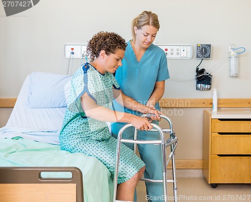 Image of Patient With Walker While Nurse Assisting Her In Hospital