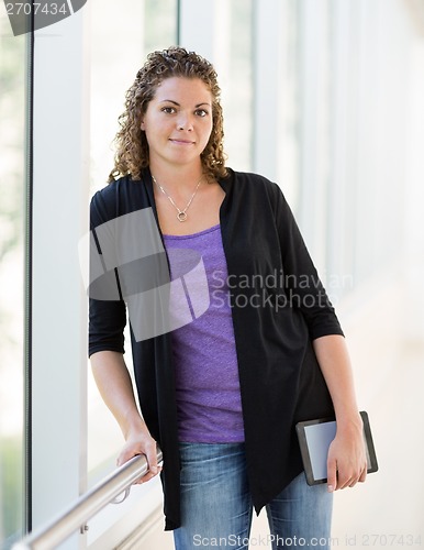 Image of Confident Student Holding Digital Tablet At University Corridor