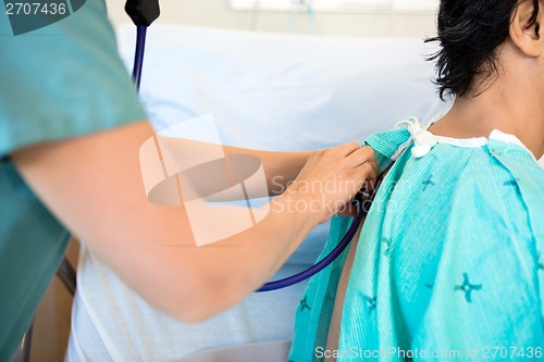 Image of Female Nurse Examining Patient's Back With Stethoscope