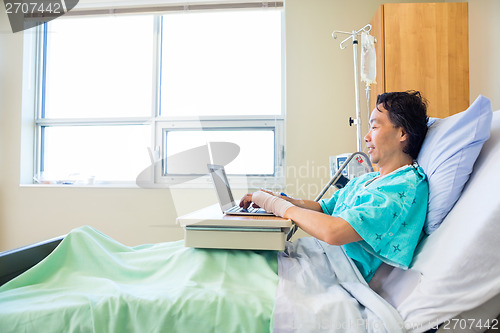 Image of Patient Using Laptop On Hospital Bed