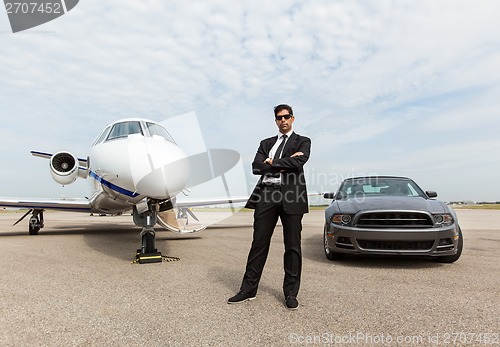 Image of Businessman Standing By Car And Private Jet At Terminal