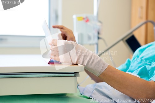 Image of Patient Using Tablet Computer While Relaxing In Hospital