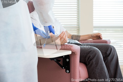 Image of Nurse Adjusting IV Drip On Patient's Hand In Chemo Room
