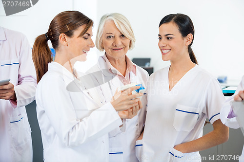 Image of Researcher With Colleagues Discussing Over Medicines