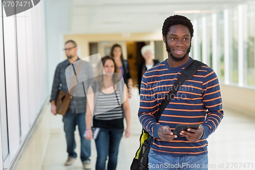 Image of Student Using Digital Tablet Down University Corridor