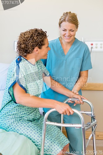 Image of Nurse Assisting Patient Using Walker In Hospital