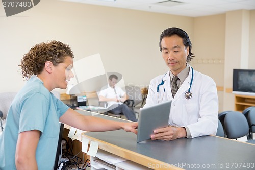 Image of Doctor And Nurse Using Digital Tablet At Reception