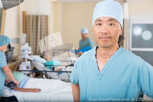 Image of Male Nurse With Colleagues Examining Patient's In Ward