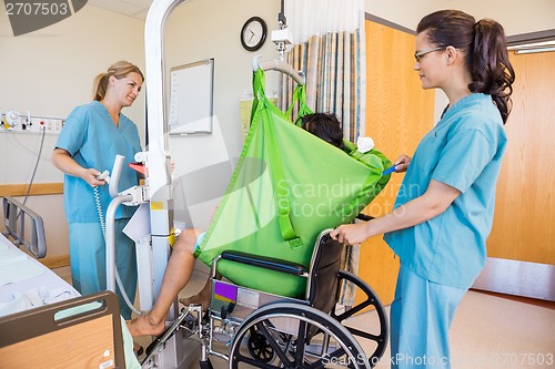 Image of Nurses Transferring Patient From Hydraulic Lift To Wheelchair