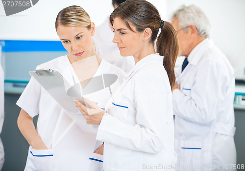 Image of Researchers Discussing Over Clipboard