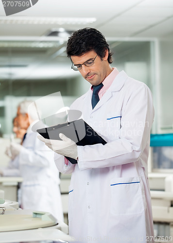 Image of Male Researcher Reading Clipboard