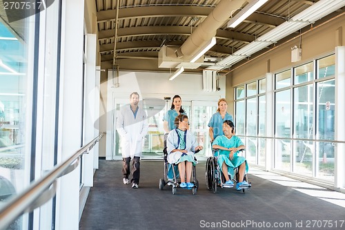 Image of Medical Team With Patients On Wheelchairs At Hospital Corridor