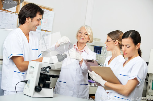 Image of Scientists Discussing Over Blood Sample In Laboratory