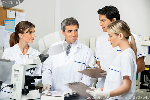 Image of Scientist With Students Taking Notes In Laboratory