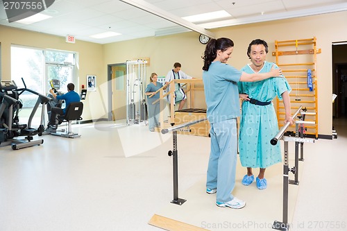 Image of Therapists Assisting Patients In Hospital Gym