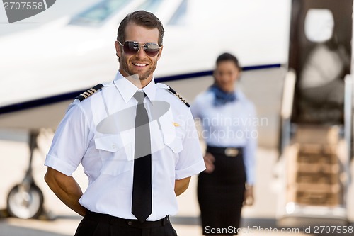 Image of Pilot Standing With Stewardess And Private Jet At Terminal