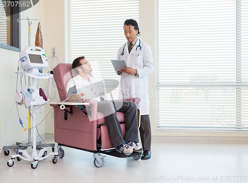 Image of Patient Looking At Doctor Using Digital Tablet In Chemo Room