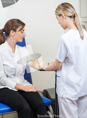 Image of Nurse Drawing Blood From Businesswoman's Arm