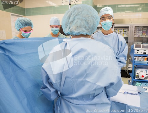 Image of Doctor With Team Operating Patient