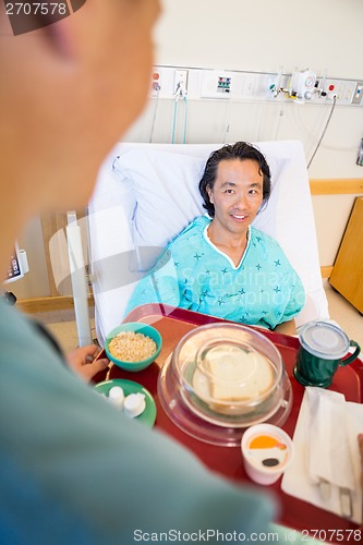 Image of Smiling Patient Looking At Nurse Serving Breakfast