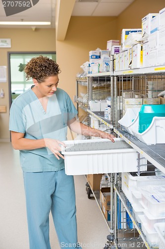 Image of Nurse Arranging Container In Storage Room