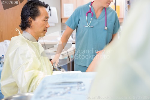 Image of Male Doctor Delivering Baby in Hospital