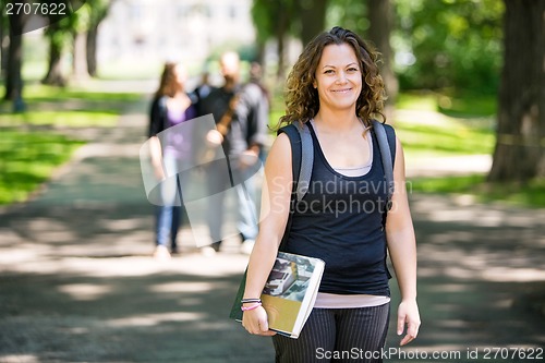 Image of Smiling Student Standing On Campus Road