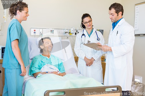 Image of Doctors Discussing Notes While Nurse And Patient Looking At Them