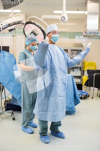 Image of Nurse Assisting Surgeon With Sterile Gown