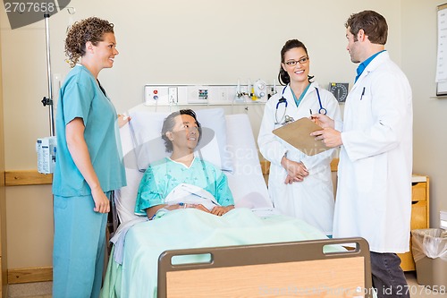 Image of Doctors Discussing Report While Nurse And Patient Looking At The