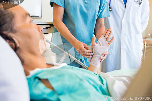 Image of Nurse Putting Bandage On Patient's Hand In Hospital