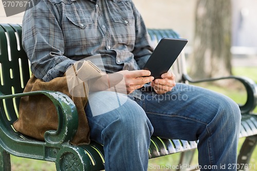 Image of Midsection Of College Student Using Digital Tablet