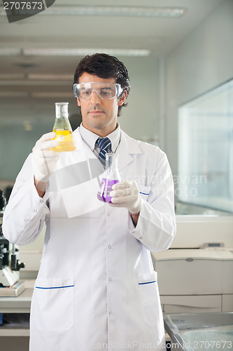 Image of Scientist Examining Flasks With Different Chemicals
