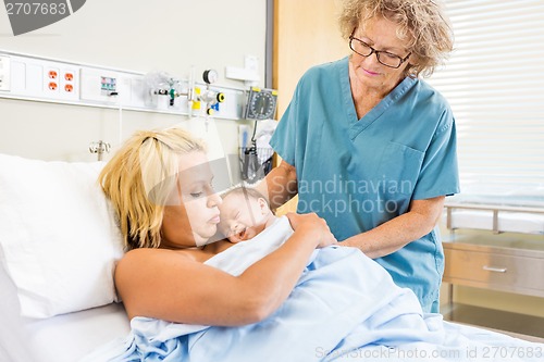 Image of Nurse Helping Young Woman with Newborn Baby