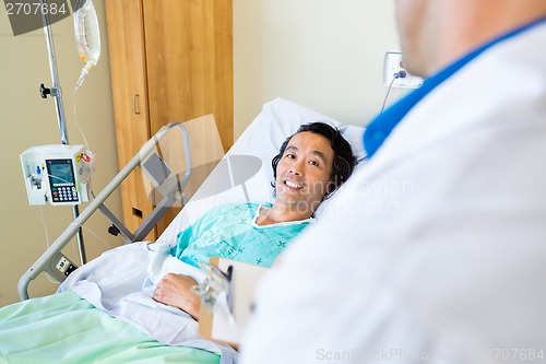 Image of Happy Patient Looking At Doctor While Lying On Hospital Bed