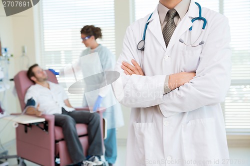 Image of Doctor Standing Arms Crossed In Chemo Room