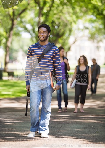 Image of Smiling Male Student Walking On Campus Road