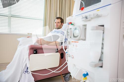 Image of Patient Holding Cellphone During Renal Dialysis Treatment