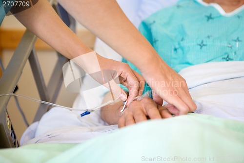 Image of Nurse Attaching IV Drip On Male Patient's Hand