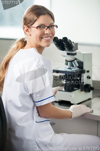 Image of Confident Female Scientist Using Microscope In Lab