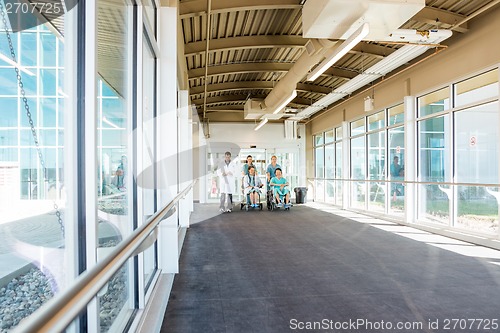 Image of Medical Team With Patients On Wheelchairs At Corridor In Hospita