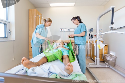 Image of Nurses Preparing Patient Before Transferring Him On Sling Lift