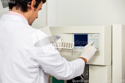 Image of Scientist With Samples Operating Analyzer In Lab