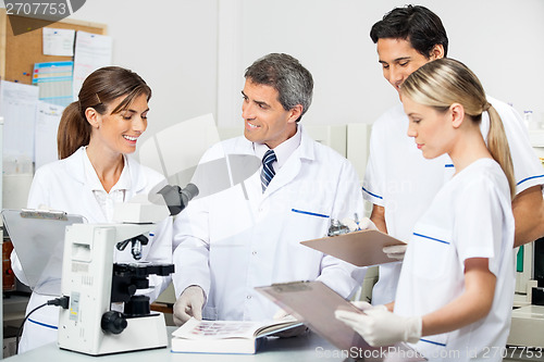 Image of Researcher With Students Taking Notes In Lab