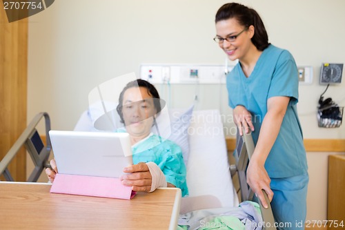 Image of Nurse And Male Patient Looking At Digital Tablet