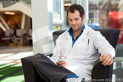 Image of Doctor Using Mobile Phone On Chair