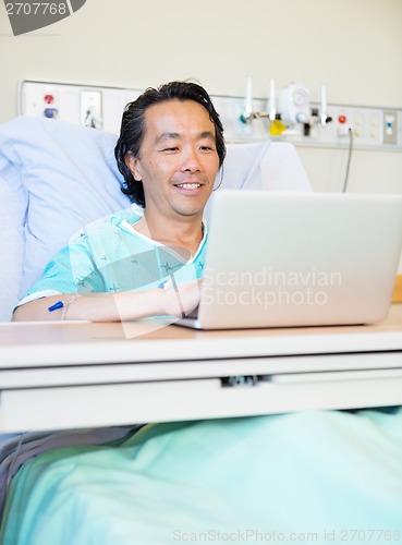 Image of Happy Patient Using Laptop On Hospital Bed