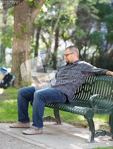 Image of College Student Using Digital Tablet On Bench