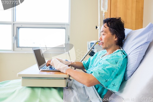 Image of Patient Using Laptop On Bed In Hospital